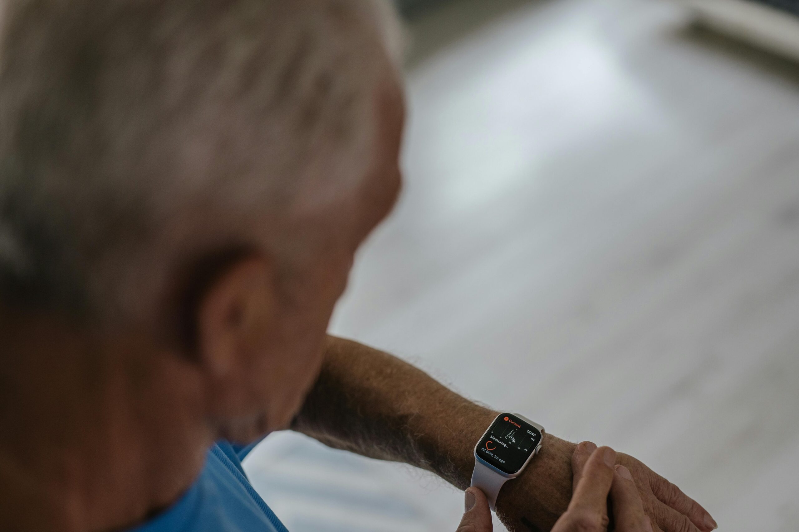 An old man looking at his smart watch